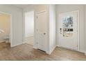 Inviting foyer with wood-look floors, a view into the living area, and a door with a glass pane at 5527 Rosehall Pl, Atlanta, GA 30349
