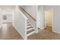 Bright foyer with wooden staircase, leading to the upper level, and beautiful wood-look floors at 5527 Rosehall Pl, Atlanta, GA 30349