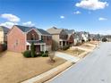 A wide street view showcases a block of attractive two-story brick homes at 28 Dover Commons Dr, Tucker, GA 30084