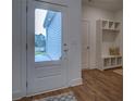 Bright entryway boasts a modern storage bench, wood floors, and a clear view of the home's exterior at 83 Malcom Rd, Covington, GA 30014