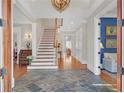 Grand foyer with slate tile flooring, staircase, and elegant chandelier at 1194 Kendrick Ne Rd, Atlanta, GA 30319