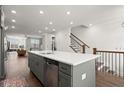 Stylish kitchen island with seating and sink, stainless steel appliances, and open view to staircase at 4000 Bethelview Ln, Suwanee, GA 30024