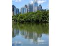 Picturesque view of the city skyline reflecting in a serene lake surrounded by lush trees at 330 9Th Ne St # 11, Atlanta, GA 30309
