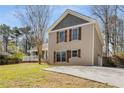 Side view of a two-story home with a concrete driveway and lawn at 2745 Davenport Rd, Duluth, GA 30096