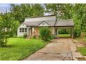 View of the home's front with a carport, lush greenery, and a quaint porch at 444 Sargent Se Dr, Atlanta, GA 30315