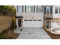 New construction townhome with two car garage, dark window shutters, and professional landscaping at 174 Sidney St, Marietta, GA 30060