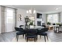 Open-concept dining area with a glass table, six velvet chairs, chandelier, and views of the living area at 512 Aberdeen Meadow Ln, Acworth, GA 30102