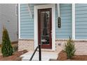 Charming entryway showcasing a wood door, brick accents, address number, and manicured landscaping at 512 Aberdeen Meadow Ln, Acworth, GA 30102