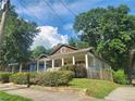 Quaint single-story home featuring a lovely front porch nestled among mature trees, creating a serene and inviting ambiance at 998 Allene Sw Ave, Atlanta, GA 30310