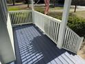 Close up on a wooden deck of a home with a white railing and blue flooring on a sunny day at 3030 Scott Rd, Marietta, GA 30066