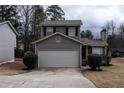 Front view of a gray two-story home with a two-car garage and a well-manicured lawn at 3934 Conley Downs Ln, Decatur, GA 30034