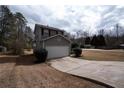 Two-story home featuring gray siding, a two-car garage, and well-maintained landscaping at 3934 Conley Downs Ln, Decatur, GA 30034