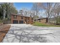 Property showcasing a neat lawn, a two-car garage, an outbuilding, and mature trees at 1072 Powell Wright Rd, Marietta, GA 30066
