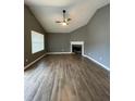 Spacious living room with vaulted ceiling, fireplace, and wood-look flooring at 163 Woodwind Way, Jonesboro, GA 30238