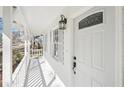Close up of the home's inviting front porch with white railings and decorative front door at 55 Sunset Rd, Mcdonough, GA 30253