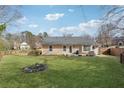 Expansive backyard featuring a lush green lawn and mature trees with a rock garden and fenced border at 10600 Willow Meadow Cir, Johns Creek, GA 30022