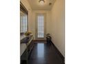 Bright hallway with dark wood floors, a decorative mirror, and a view of the front door at 3318 Sardis Bend Dr, Buford, GA 30519