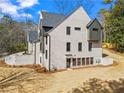 Rear exterior view of a two-story home with brick, siding, dark window frames, and unfinished yard at 88 Lakeshore Ne Cir, Marietta, GA 30067