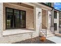 Covered entryway with brick columns, modern lighting, and metal handrails on steps at 88 Lakeshore Ne Cir, Marietta, GA 30067