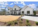 Expansive front lawn with professionally landscaped yard showcasing the striking design of the two-story white brick home at 4100 Thunderbird Dr, Marietta, GA 30067