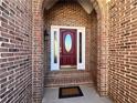 Elegant red front door framed by brick, with sidelights and a decorative oval glass insert at 8008 Revere Dr, Mcdonough, GA 30252
