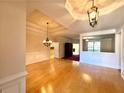 Spacious living room features gleaming hardwood floors, wainscoting, and elegant chandeliers at 8008 Revere Dr, Mcdonough, GA 30252