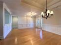 Open living area with hardwood floors, decorative wainscoting, and a view of the front entrance at 8008 Revere Dr, Mcdonough, GA 30252