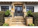 Inviting stone front entrance with black framed glass door, detailed stonework, and manicured landscaping at 1100 Virginia Ne Ave, Atlanta, GA 30306