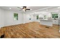 Open-concept living room with hardwood floors, ceiling fan, and kitchen access at 1583 Columbia Cir, Decatur, GA 30032