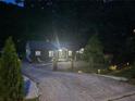 Night view of charming single-story home with well-maintained landscaping and long driveway with ample parking at 2077 Brockett Rd, Tucker, GA 30084