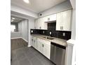 View of the kitchen showcases modern design with granite countertops, white cabinets, and tiled floor at 1502 Huntingdon Chase, Atlanta, GA 30350