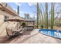 Inviting backyard with wooden deck, above ground pool, outdoor bar, and table with seating at 3175 Pond Ridge Trl, Snellville, GA 30078