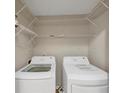 A well-organized laundry room with a washer, dryer, and wire shelving for storage at 742 Wilkes Dr, Loganville, GA 30052