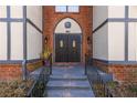 Close up of the main building entrance with brick archway, stairs, and black double doors at 6851 Roswell Rd # L1, Atlanta, GA 30328