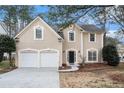 Charming two-story home with a two-car garage, neutral stucco exterior, and landscaped front yard with mature trees at 725 Victoria Station Blvd, Lawrenceville, GA 30043