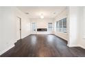 Spacious living room with hardwood flooring, a modern fireplace, large windows, and neutral white paint at 725 Victoria Station Blvd, Lawrenceville, GA 30043