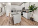 Bright eat-in kitchen features granite countertops, stainless steel appliances, an island, and wood flooring at 9464 Cedar Grove Ct # 327, Jonesboro, GA 30238