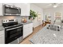 Eat-in kitchen features stainless steel appliances, white cabinetry, and granite countertops at 9464 Cedar Grove Ct # 327, Jonesboro, GA 30238
