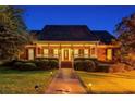 Charming single-story brick home featuring a welcoming front porch, manicured lawn, and lush landscaping at 1408 Aramore Dr, Conyers, GA 30013