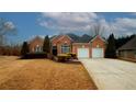 Charming brick home featuring a manicured lawn, trimmed hedges, and a two-car garage at 165 Arbor Creek Way, Roswell, GA 30076