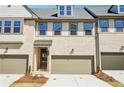 Townhome exterior with two-car garage, light brick facade, covered entry, and landscaped front yard at 3900 Allegretto Cir # 51, Atlanta, GA 30339