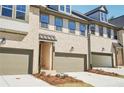 Attractive townhome exteriors featuring two-car garages, light brick, covered entryways, and clean landscaping at 3900 Allegretto Cir # 51, Atlanta, GA 30339