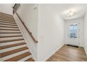 Bright foyer featuring hardwood floors, staircase with wooden handrail, and a glass-paneled front door at 3900 Allegretto Cir # 51, Atlanta, GA 30339