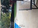 Outdoor pool area featuring a table, umbrella, concrete patio, and privacy landscaping at 222 Waterford Cove Dr, Suwanee, GA 30024