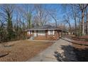 Cozy single-story brick house with a long driveway and a simple, welcoming design surrounded by trees at 1160 Kathryn Cir, Forest Park, GA 30297