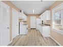 Bright kitchen featuring white cabinets, appliances, a window, and wood-look floors, great for meal preparation at 1160 Kathryn Cir, Forest Park, GA 30297