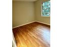 This bedroom features hardwood floors, neutral walls, and a window providing natural light at 2574 Stratford Ln, Morrow, GA 30260