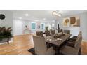 Elegant dining area with a long wooden table, seating for ten, and contemporary light fixture at 4647 Wonder Valley Trl, Decatur, GA 30034