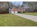 Charming brick home featuring an attached two-car garage and a spacious front yard at 504 Trotters Ln, Mcdonough, GA 30252