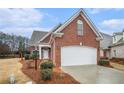 Well-maintained two-story brick home featuring a two-car garage and classic architectural details at 1550 Woodberry Run Dr, Snellville, GA 30078